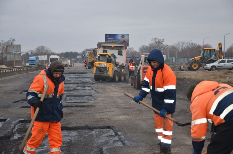 На київській трасі почали засипати величезні ями (фото, відео)